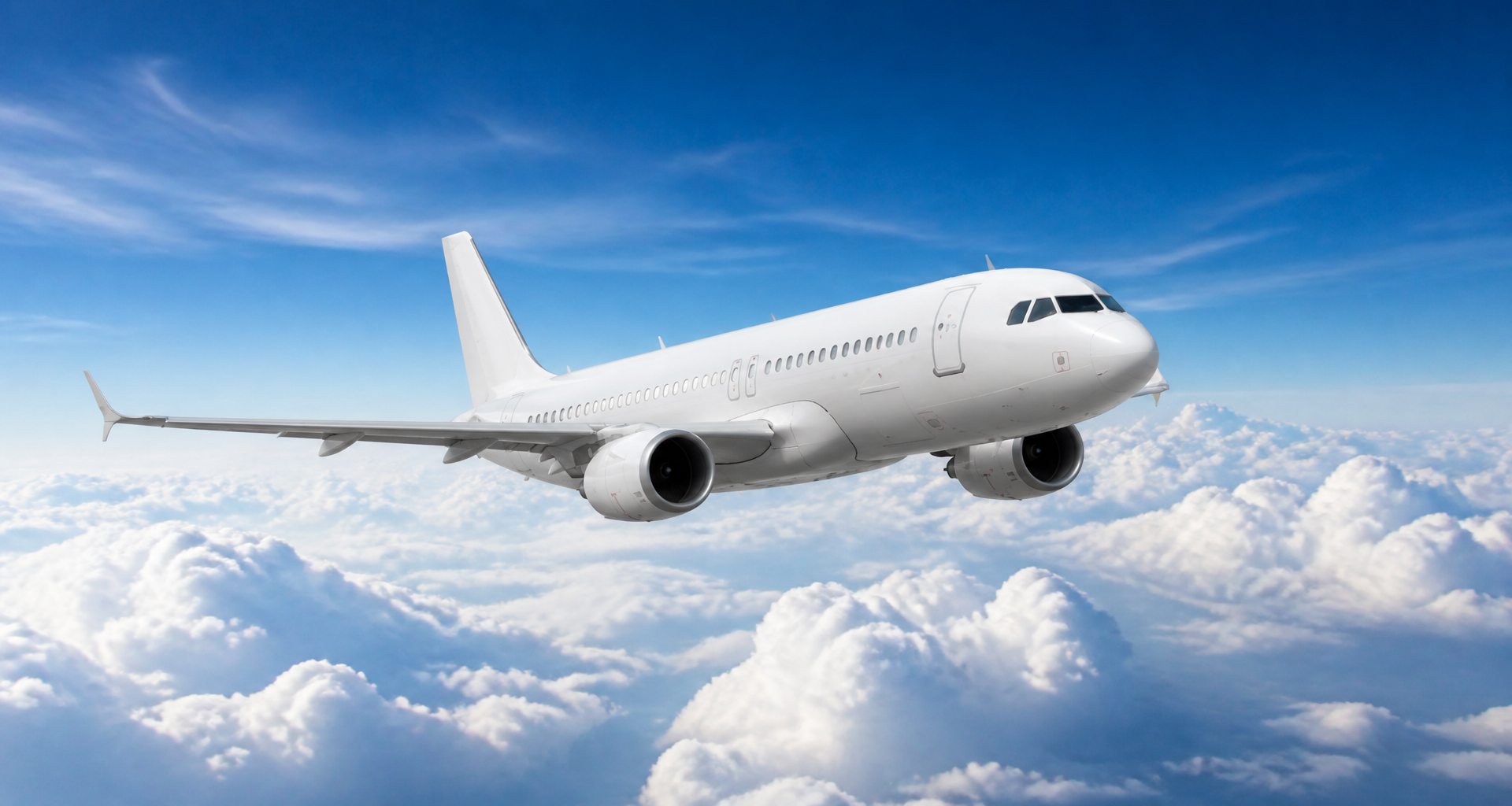 Commercial airliner flying high above the clouds in daytime